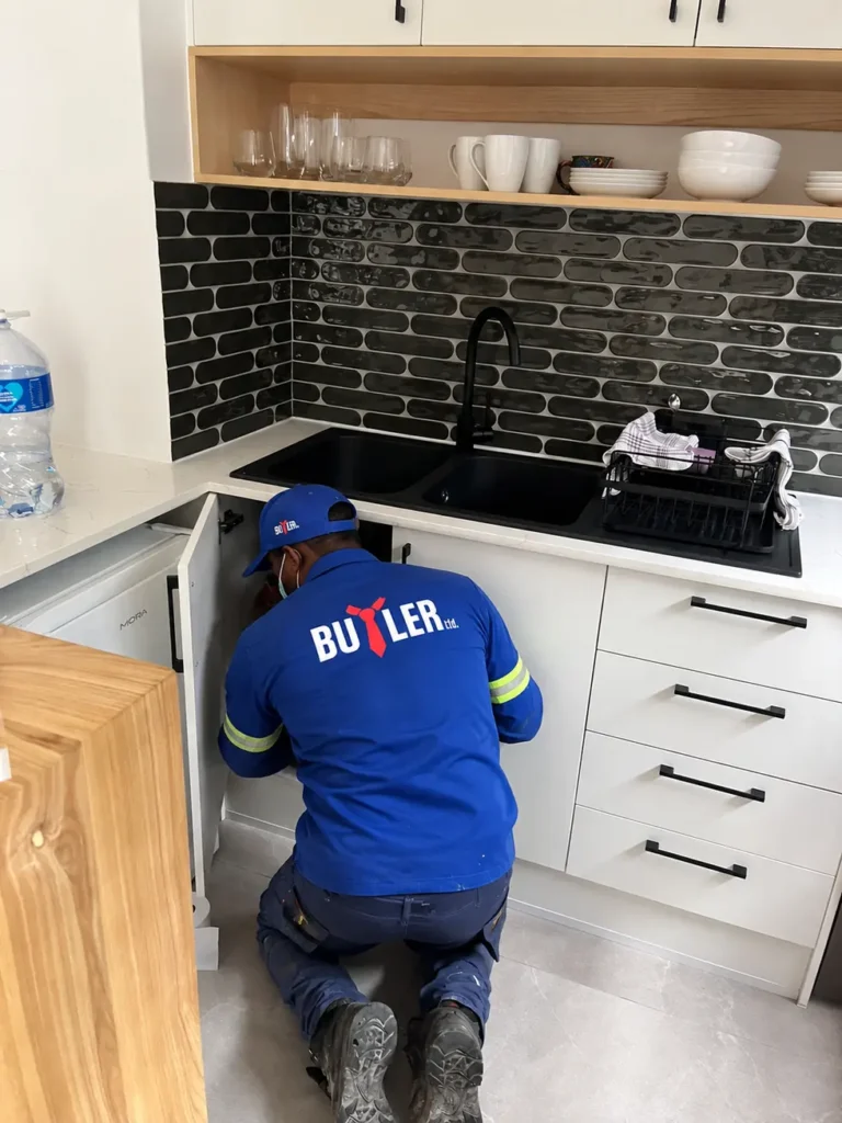 Butler Ltd technician treating a kitchen during a pest control service